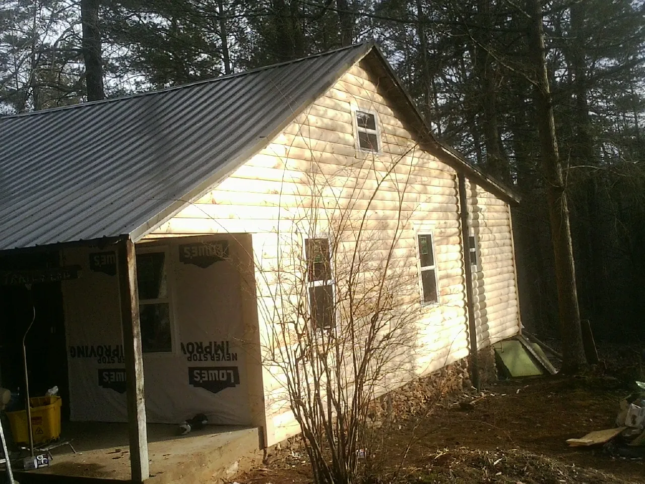 Log siding gable end under a dark metal roof edge in Bountiful