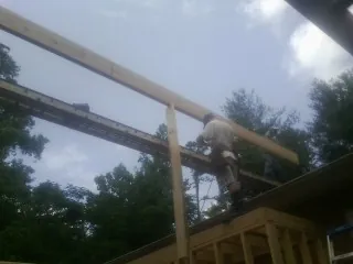 Carpenter setting a ridge beam over a new addition frame — Ice Dam Removal by Roofing Brothers in Bountiful