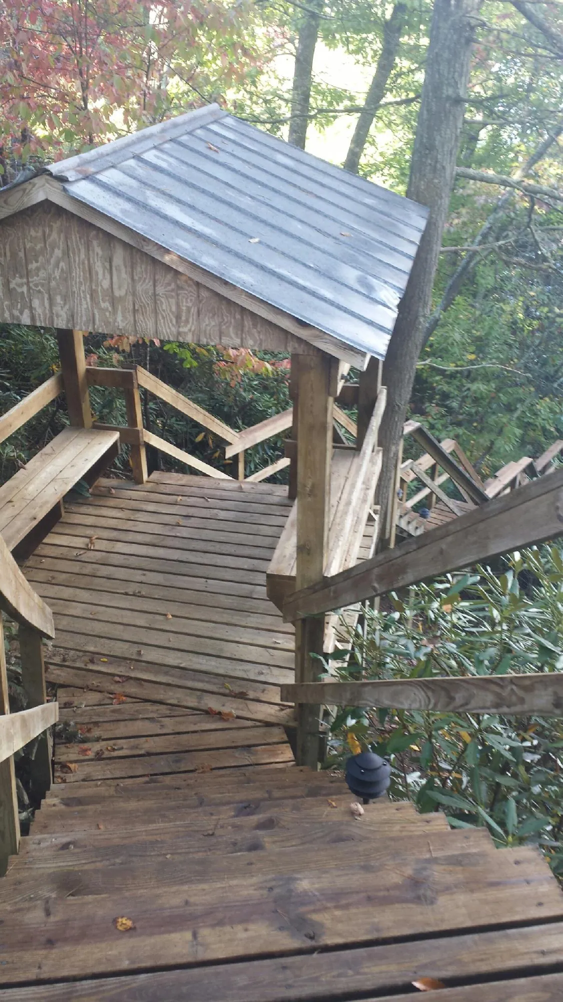 Metal roofed shelter over wooden steps on a wooded walkway — Skylight Repair & Installation work by our crew in Bountiful