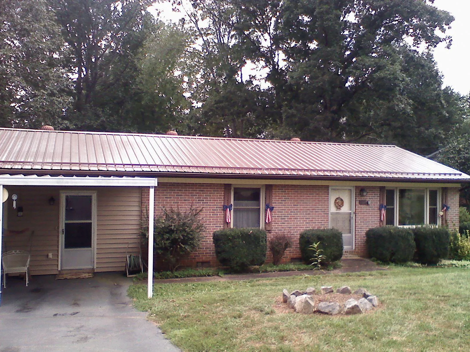 Bronze metal roof and carport on a brick ranch home — Roof Repair work by our crew in Bountiful