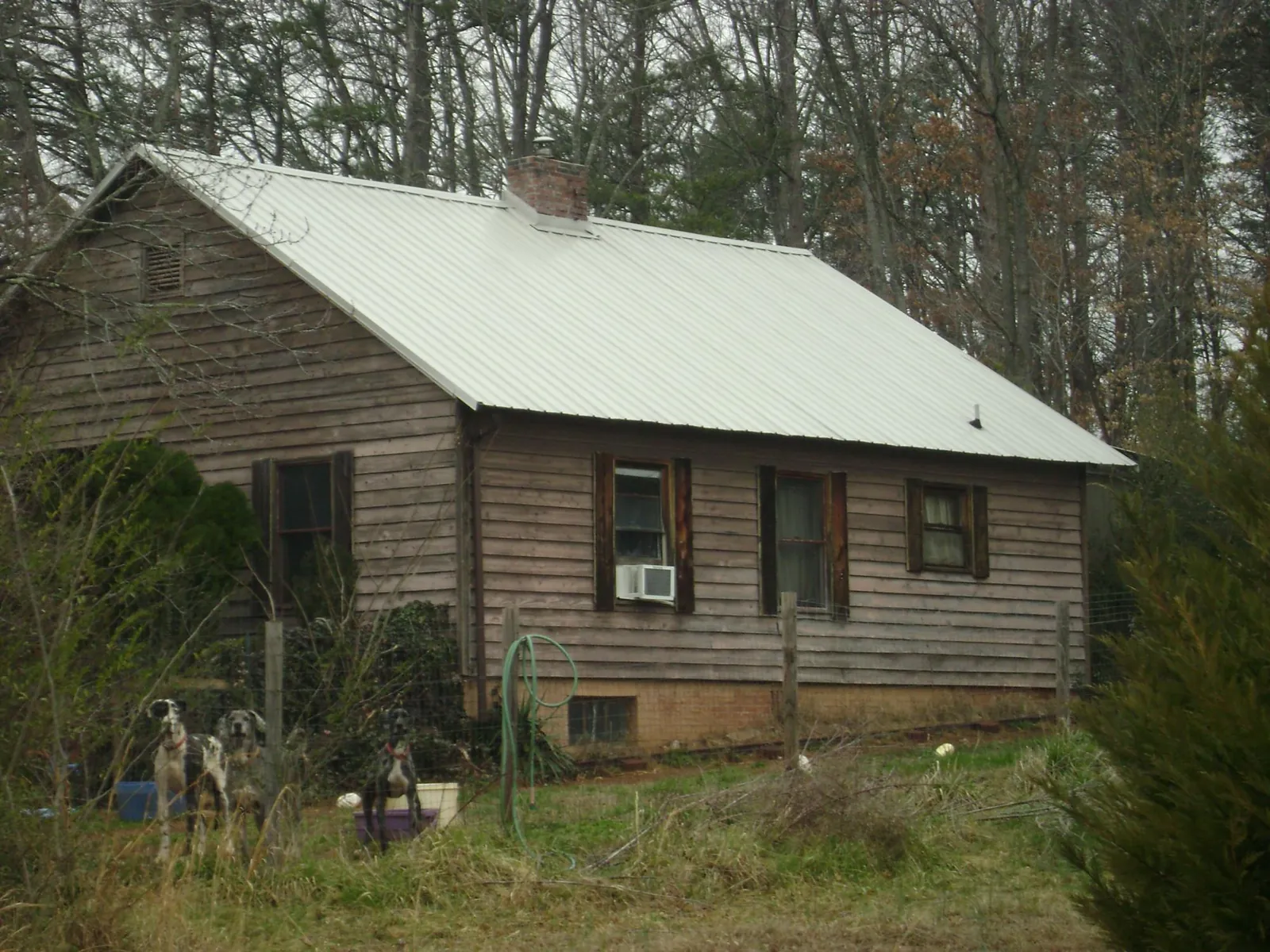 White metal roof on an old wood sided farmhouse, from a Metal Roof Installation job in Bountiful